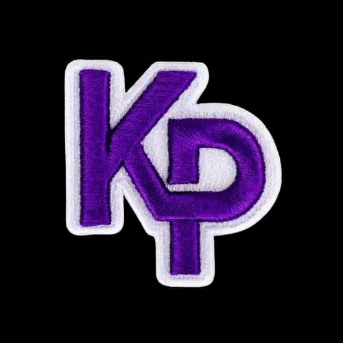 A close-up of custom purple interlocking KP letters demonstrating sharp, high-density 3D puff embroidery digitizing.