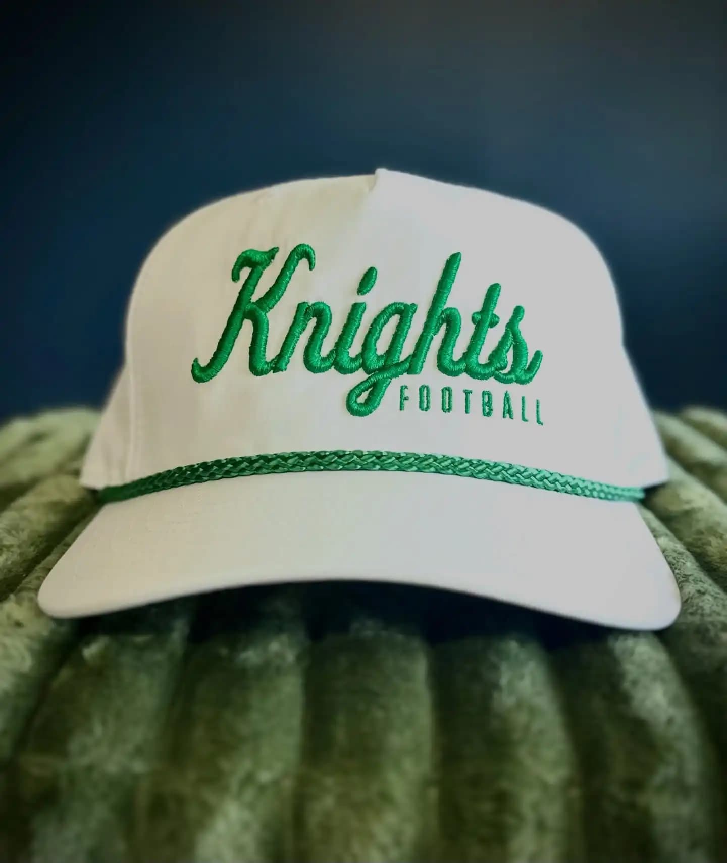 Knights Football team logo with green 3D puff script on a white rope hat, showcasing 100% manual digitizing by Sassy Digitizing for high-profile athletic headwear.